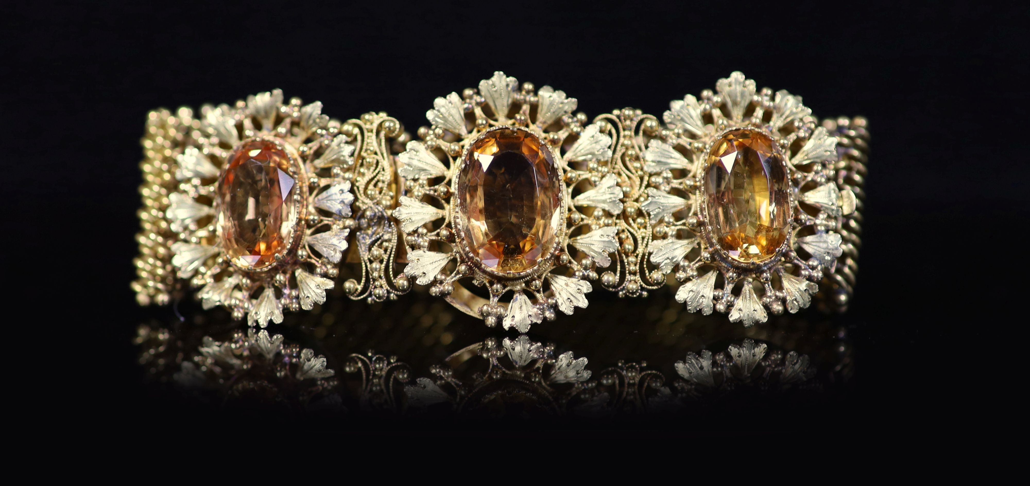 An early 19th century two colour gold and three stone oval cut topaz set bracelet